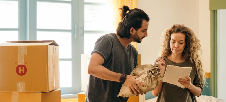 Top 5 mistakes to avoid when moving in Cincinnati 1 two people packing while discussing mistakes to avoid when moving in Cincinnati