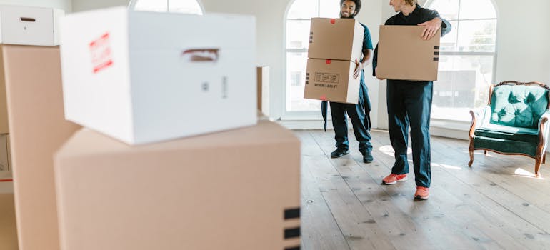 How to Downsize Your Belongings Before Moving to Cincinnati 3 two movers taking out the boxes, ilustrating how to downsize your belongings for a move