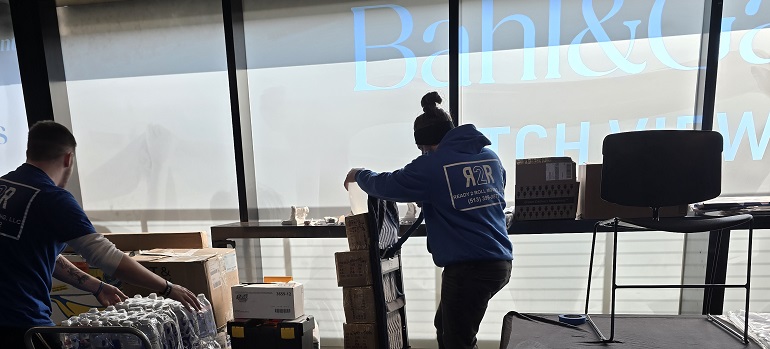 Why are companies moving to Ohio? 1 two employees of Ready 2 Roll in blue branded shirts packing boxes in and talking about why are companies moving to Ohio a modern office space