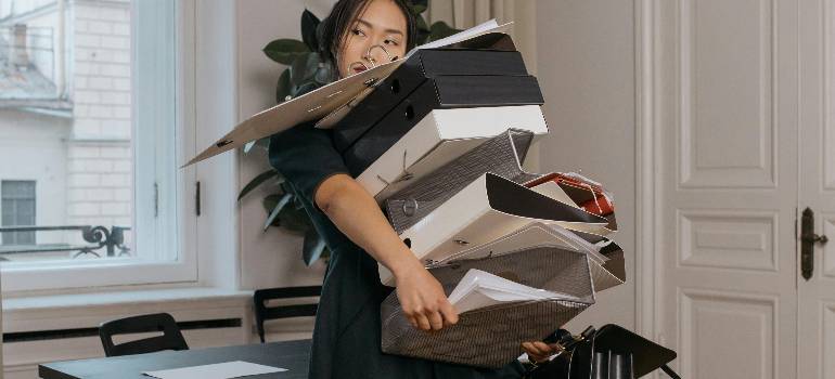Do you love your clutter? 2 Overwhelmed woman carrying folders, asking herself do you love your clutter