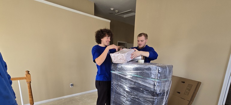 Tackling hoarding before a move 3 Professional movers wrapping protected furniture on moving day